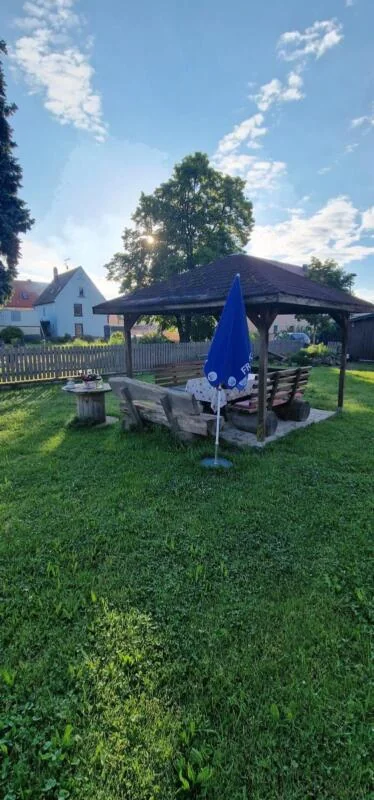 Überdachter Sitzplatz auf der Wiese neben der Anlage